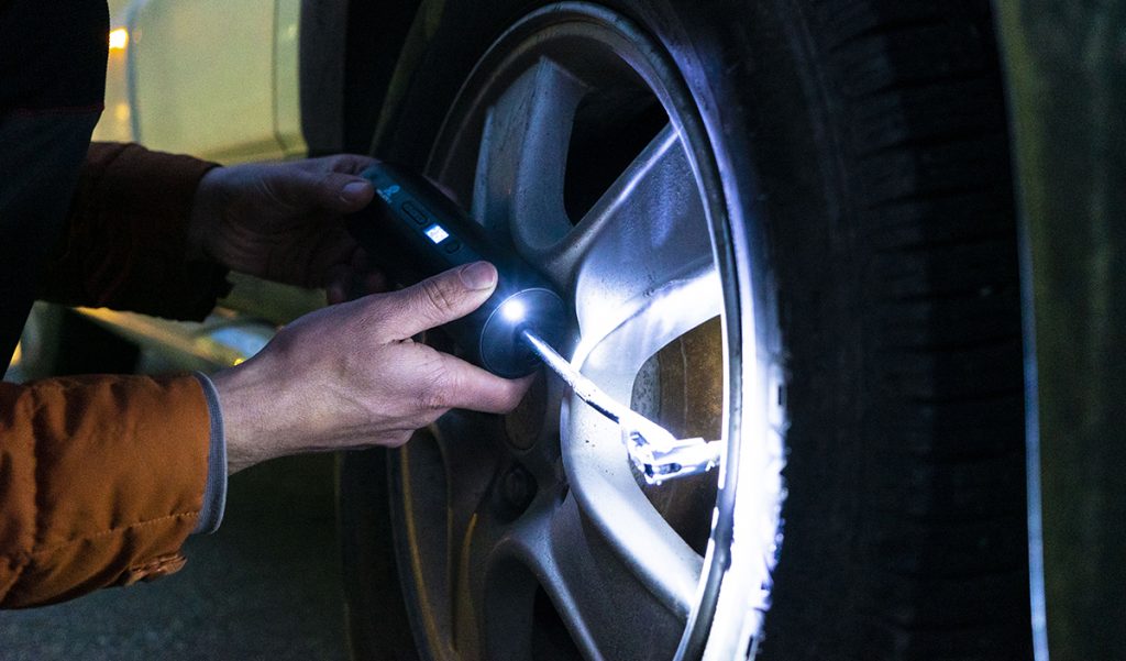 Someone filling air in car tyre with Inflater