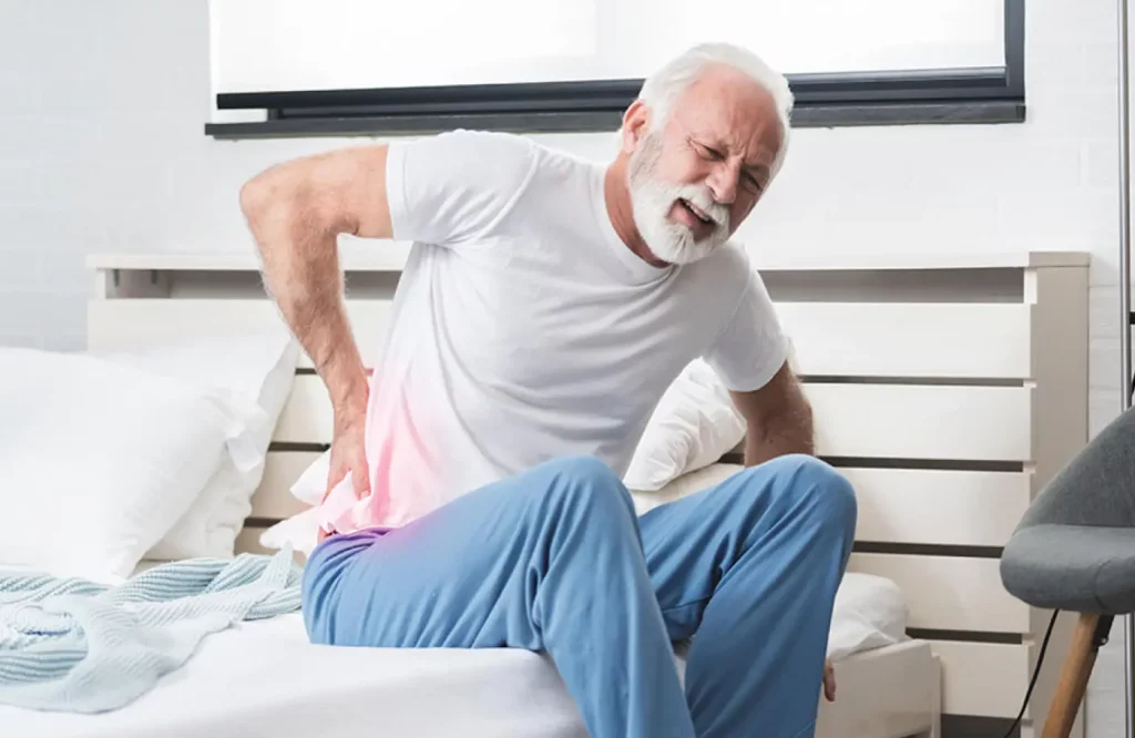 An old man experiencing back pain